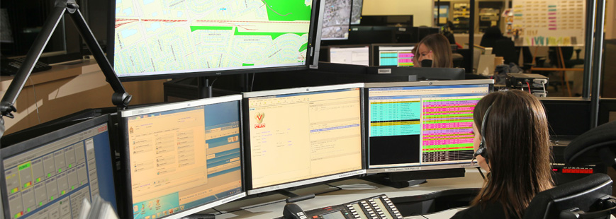 Multiple computer screens and maps in 911 comms centre