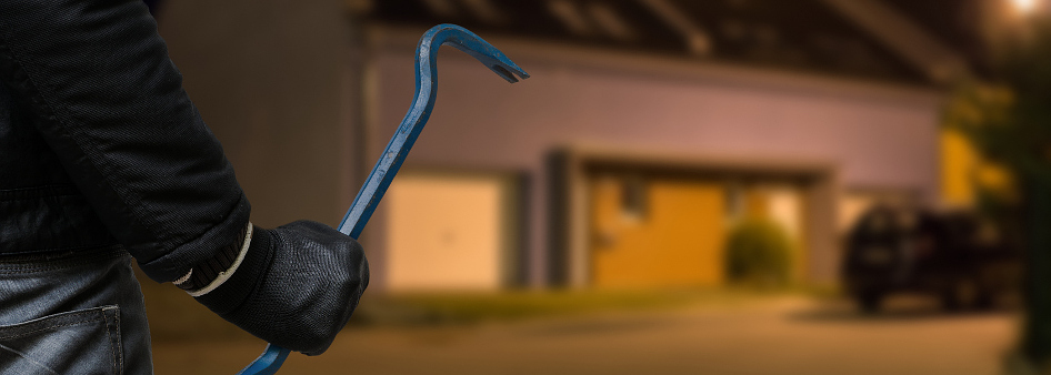 criminal walking at night with gloved hand and blue crowbar