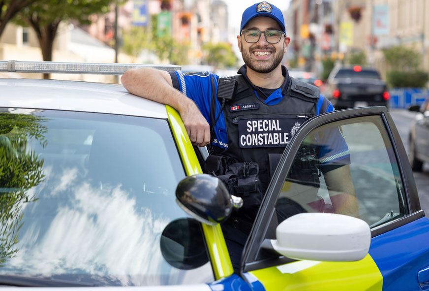 Special Constable, leaning on Special Constable Cruiser