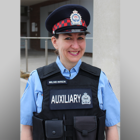 female auxilliary officer in uniform, standing in archway, smiling enthusiastically