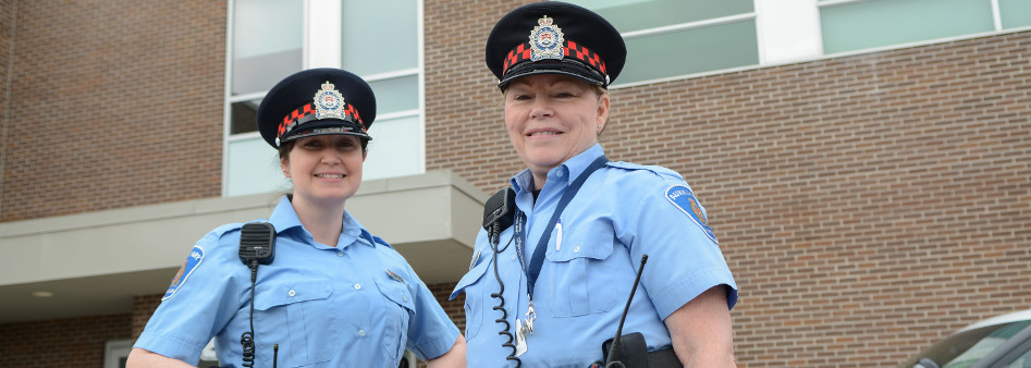 Two female Auxiliary Officers standing in front of LPS HQ